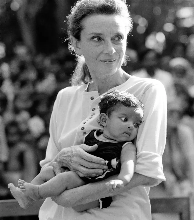 mulher segura crian&ccedil;a no colo