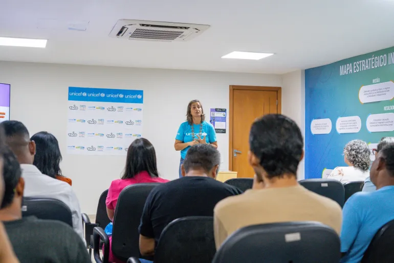 funcion&aacute;ria do UNICEF fala para plat&eacute;ia