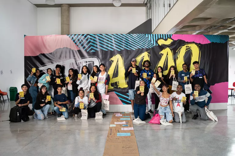Foto mostra um monte de jovens reunidos, posando para a foto.