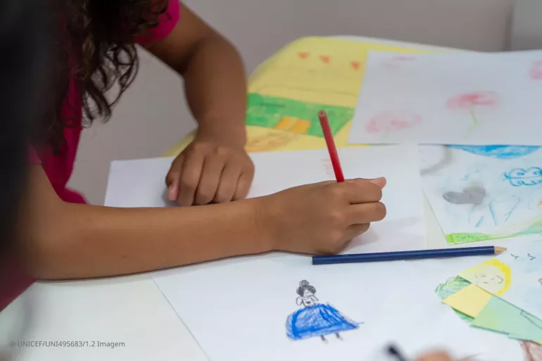 menina desenha em papel