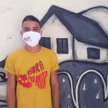 Clebson Moura de m&aacute;scara em frente a uma arte na parede