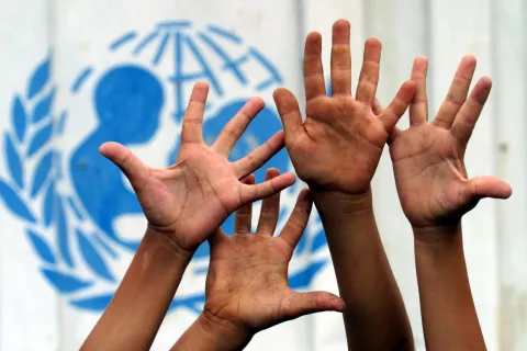 Raised hands in front of UNICEF's logo 