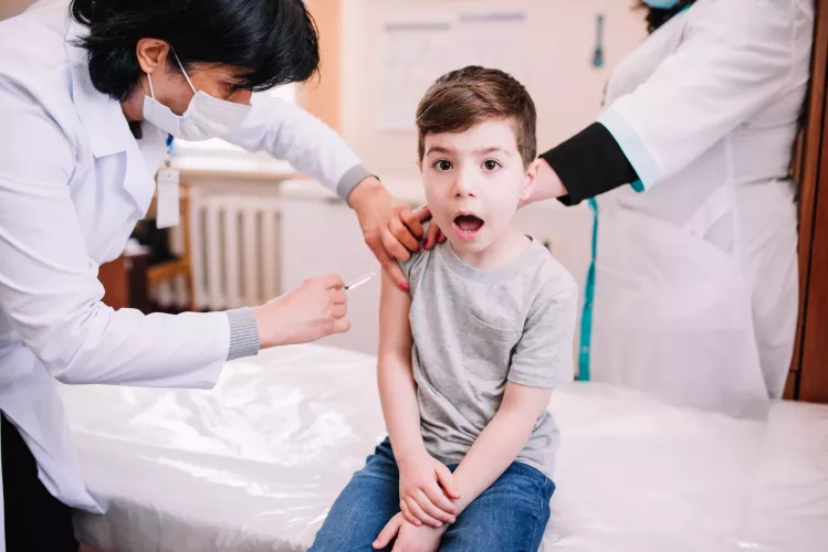Момче получава ваксина от лекар