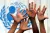 Детски ръце са вдигнати пред логото на УНИЦЕФ