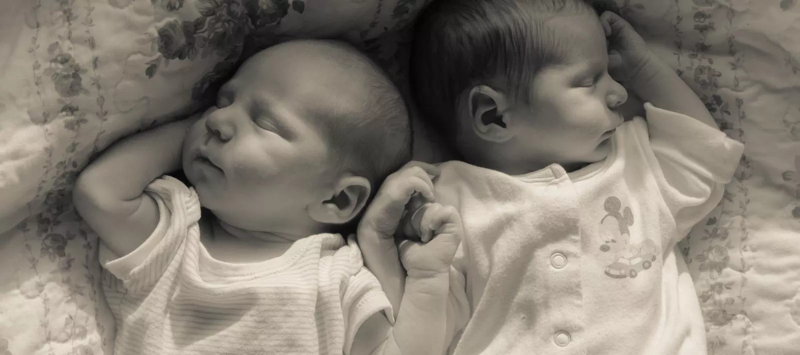 Two babies - twins are lying on their bed. 