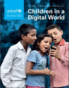 Three children are watching something interesting on a mobile phone. 