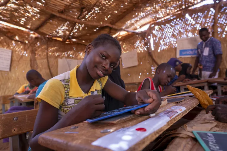 Sawadogo Odette est en train d&rsquo;&eacute;crire sur son ardoise 