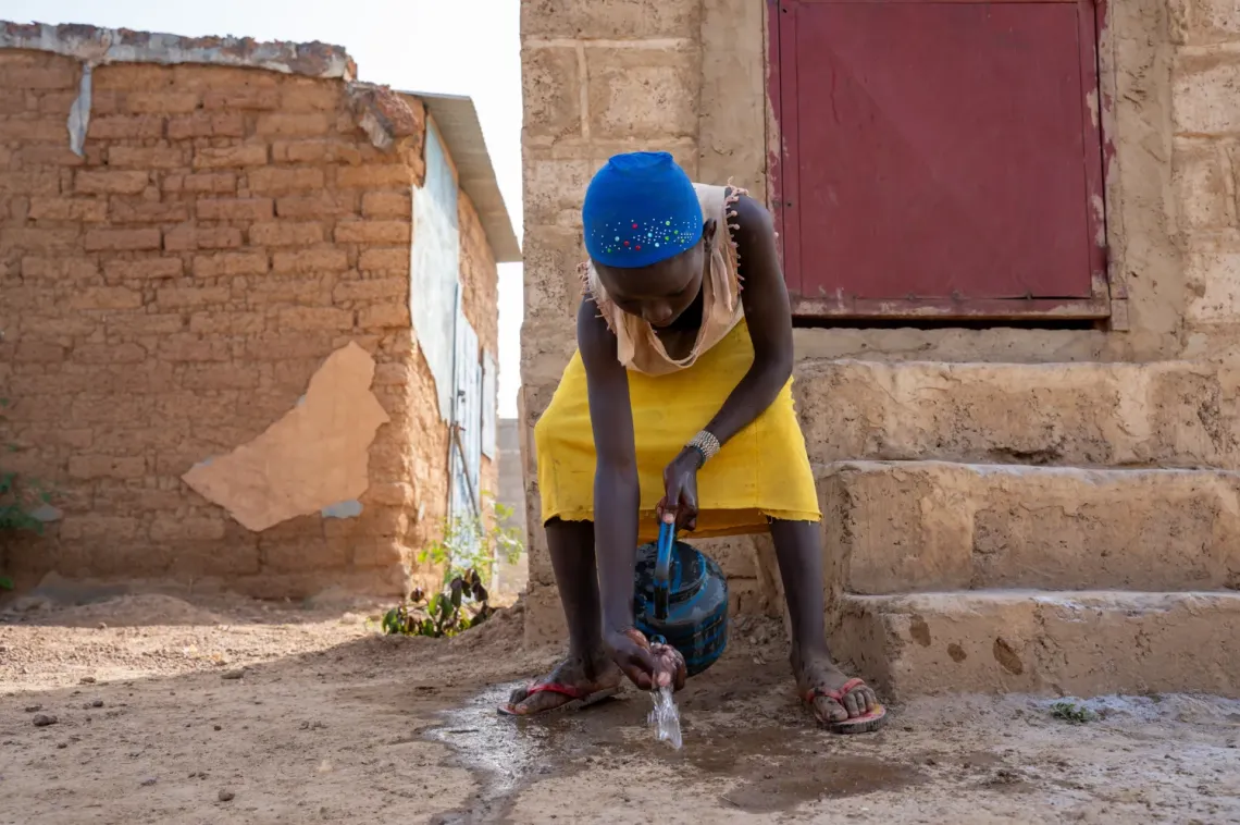 Pauline lave ses mains avec la cendre apr&egrave;s avoir utilis&eacute; les latrines 