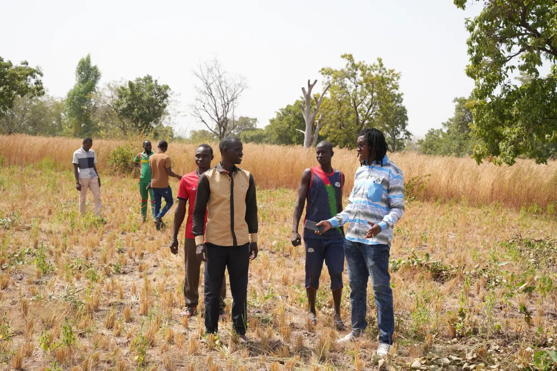 Le coordonnateur Cheick Tidiane (&agrave; l&rsquo;extr&ecirc;me droite) &eacute;change avec des habitants dans un champ fertilis&eacute; gr&acirc;ce aux produits d&eacute;riv&eacute;s des latrines ECOSAN.