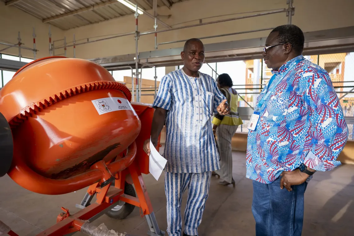 Adama Traor&eacute;, an education specialist at UNICEF, is talking near the cement mixer with the director of the Koumdagnonr&eacute; college.