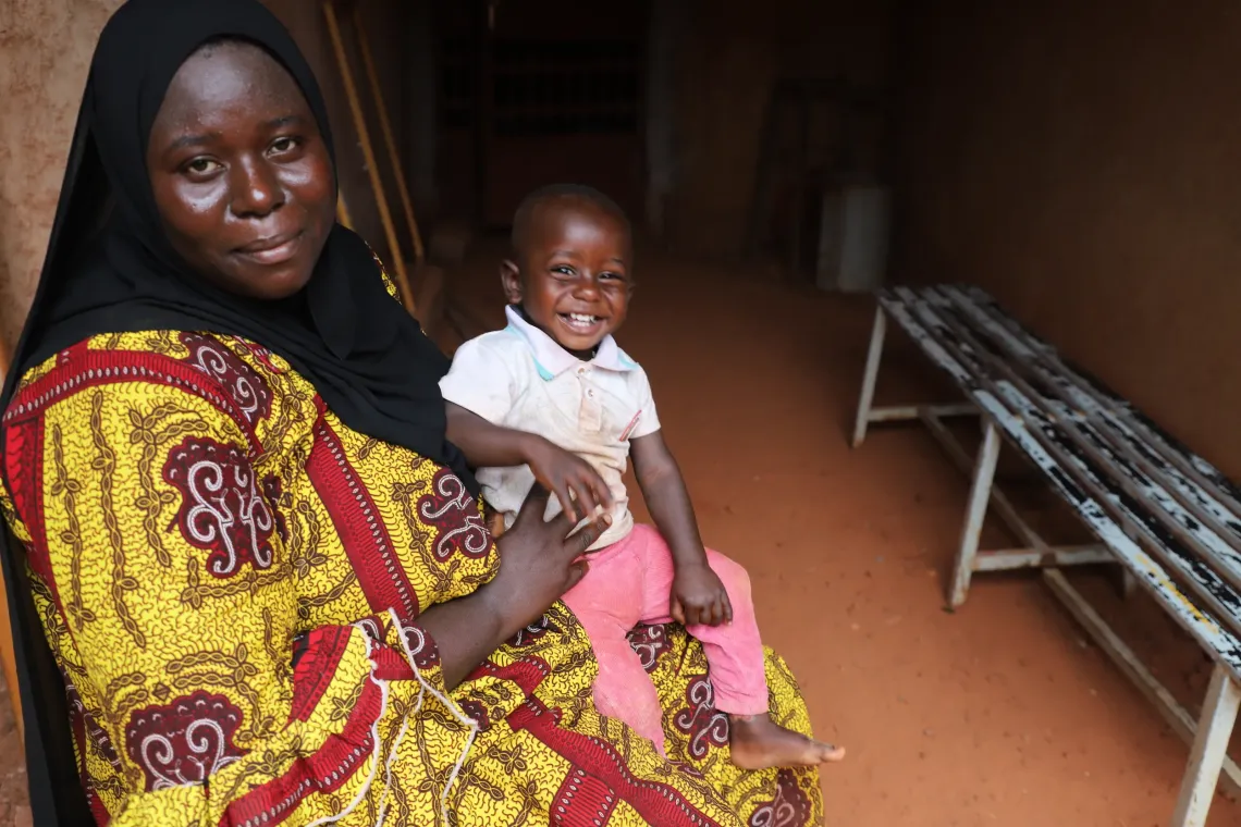 Moctar est assis sur les cuisses de sa m&egrave;re apr&egrave;s la suppl&eacute;mentation en vitamine A &agrave; Bobo-Dioulasso au Burkina Faso.