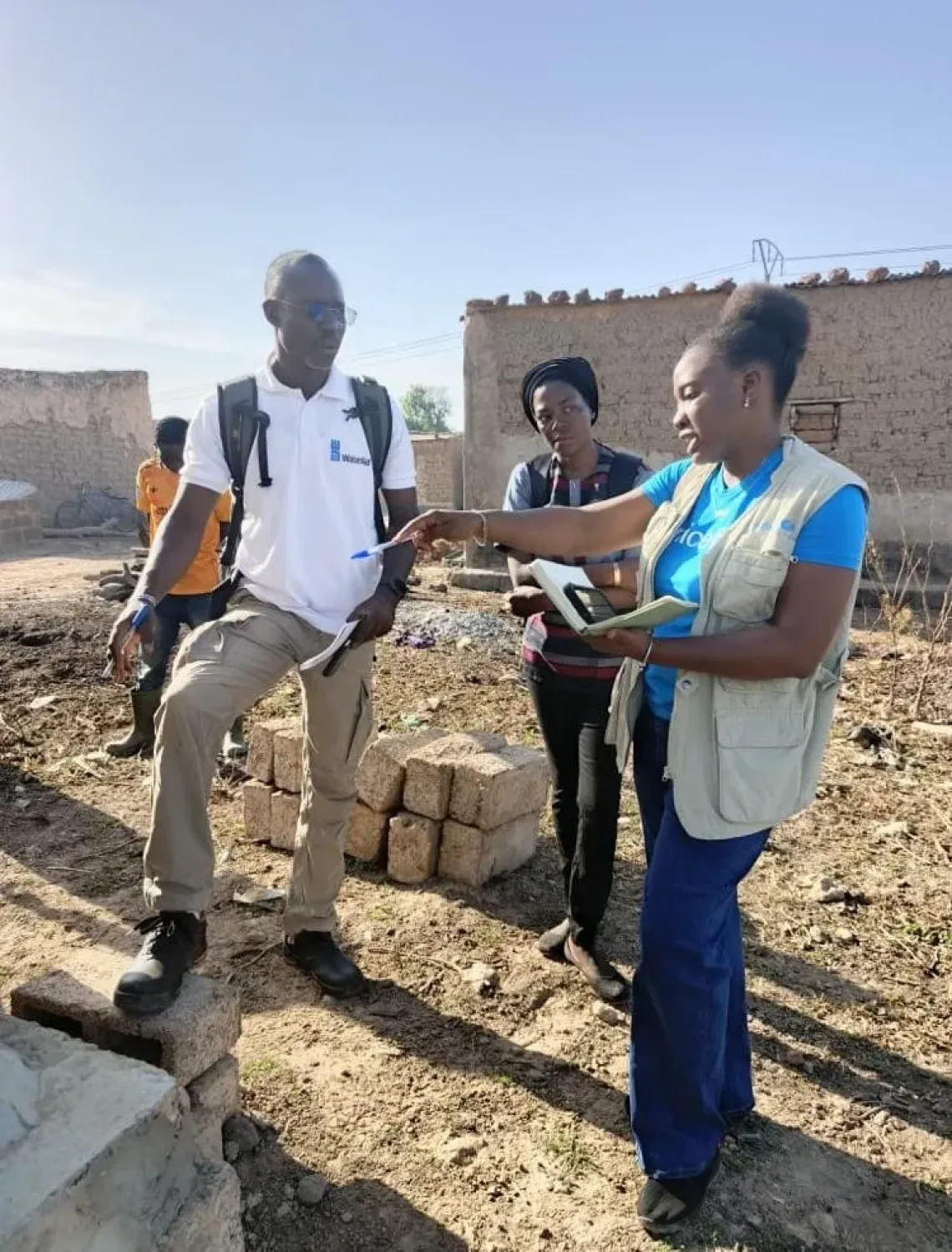 Grace Yoni discute de la r&eacute;alisation de latrines avec un partenaire sur le terrain. 