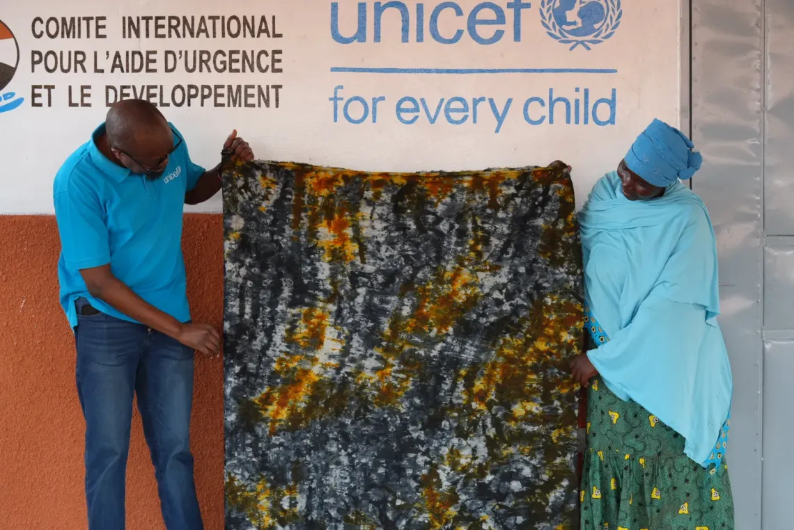 Avec admiration, Dan Rono, chef de la section protection &agrave; l&rsquo;UNICEF, observe le pagne K&ocirc;k&ocirc; Dunda que Saratou a confectionn&eacute;