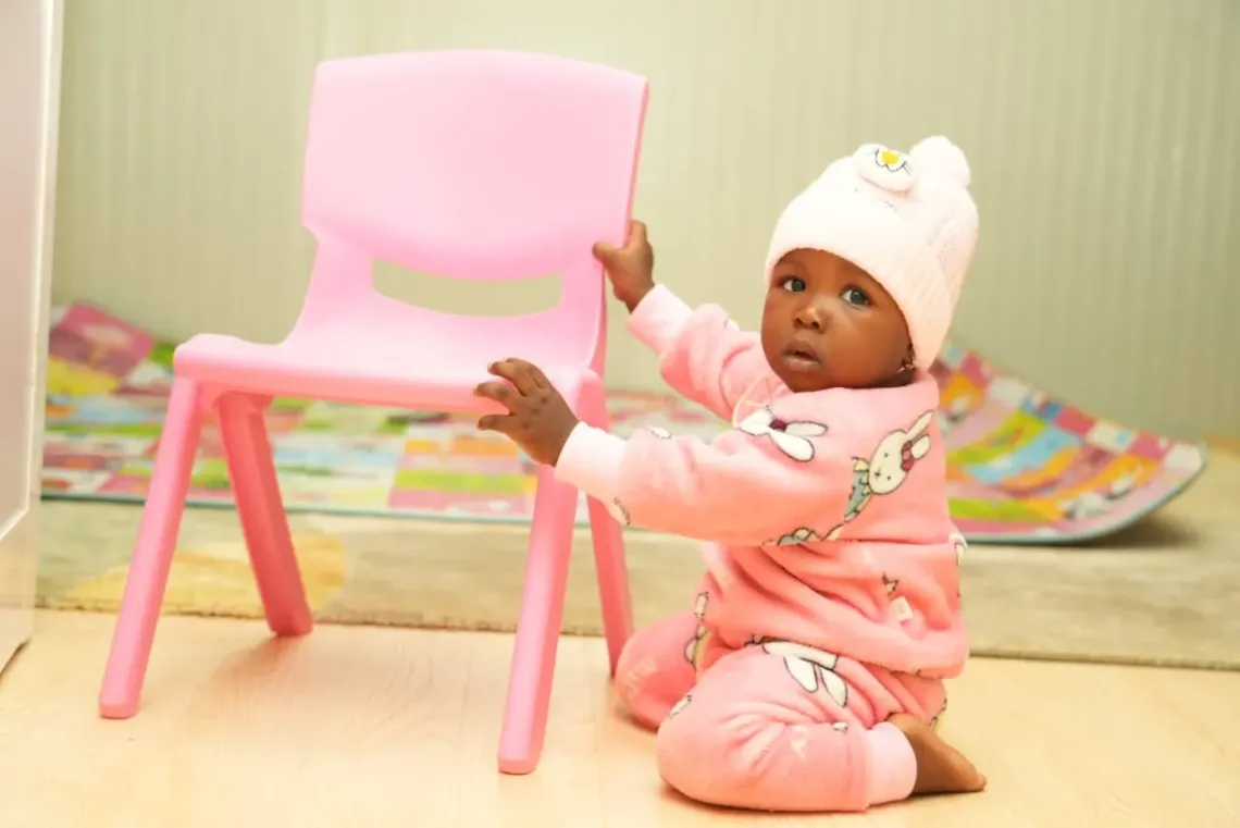 Gloria, &acirc;g&eacute;e de neuf mois, est assise dans la salle de jeu o&ugrave; elle passe du temps apr&egrave;s avoir &eacute;t&eacute; allait&eacute;e par sa m&egrave;re.