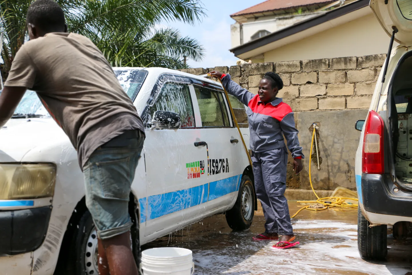Evelyne washes a cab driver's car