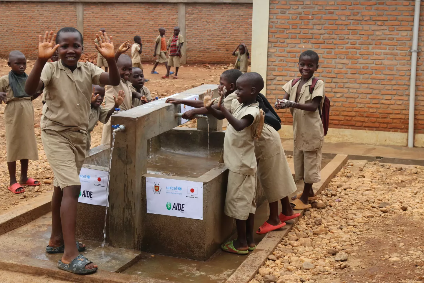 Des &eacute;coliers de l'ECOFO Nyakagunda se lavent les mains avec la rampe d'eau install&eacute;e par l'UNICEF.