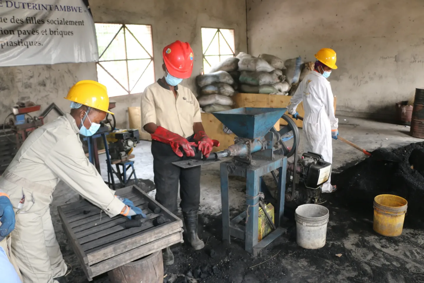 De jeunes filles encadr&eacute;s par UCBUM &agrave; travers un centre des m&eacute;tiers en train d'apprendre recycler les d&eacute;chets plastiques en charbon. 