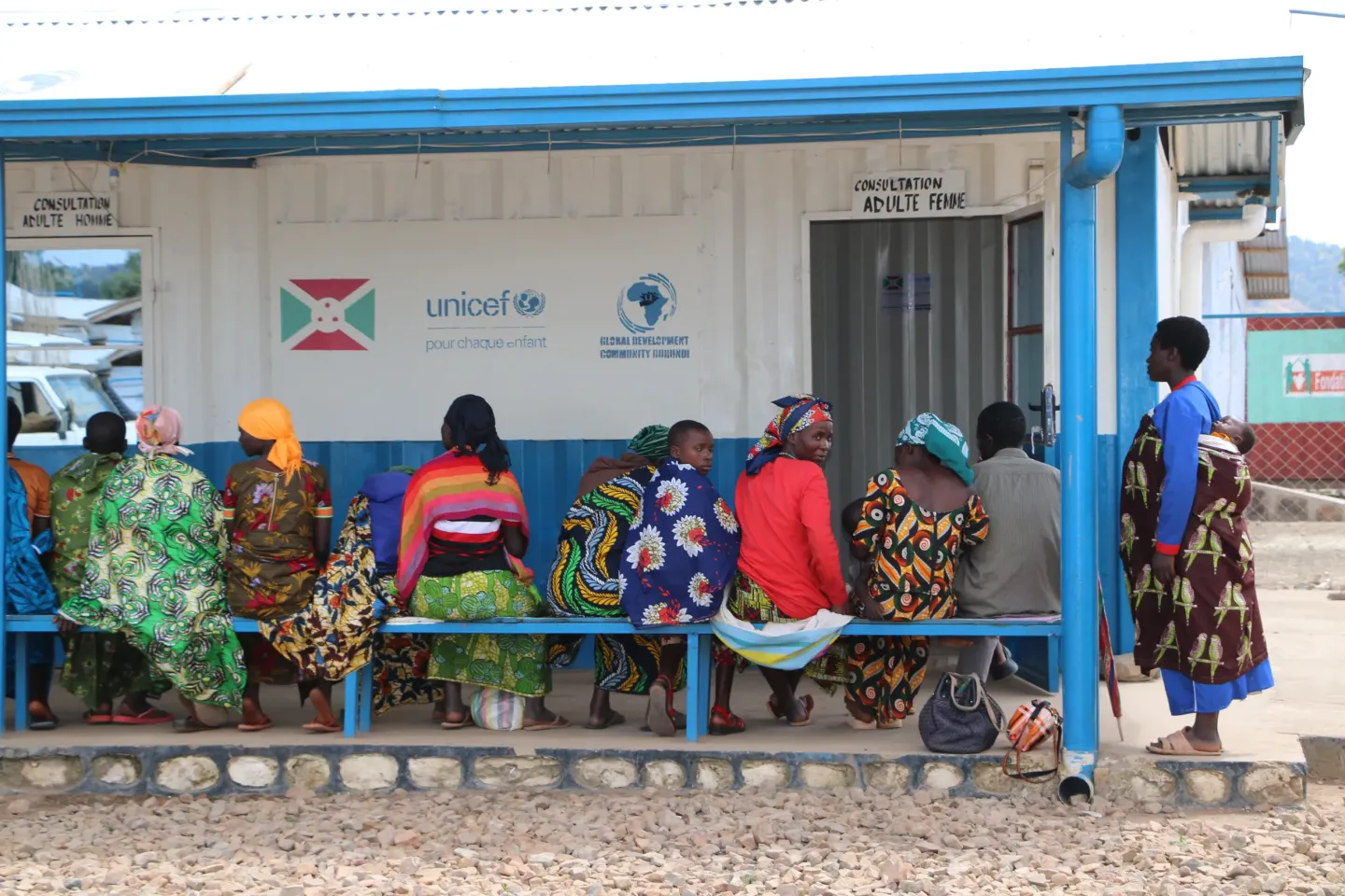 Seated on benches outside the Musenyi mobile clinic, Congolese refugees and members of the host community wait to receive medical care.  