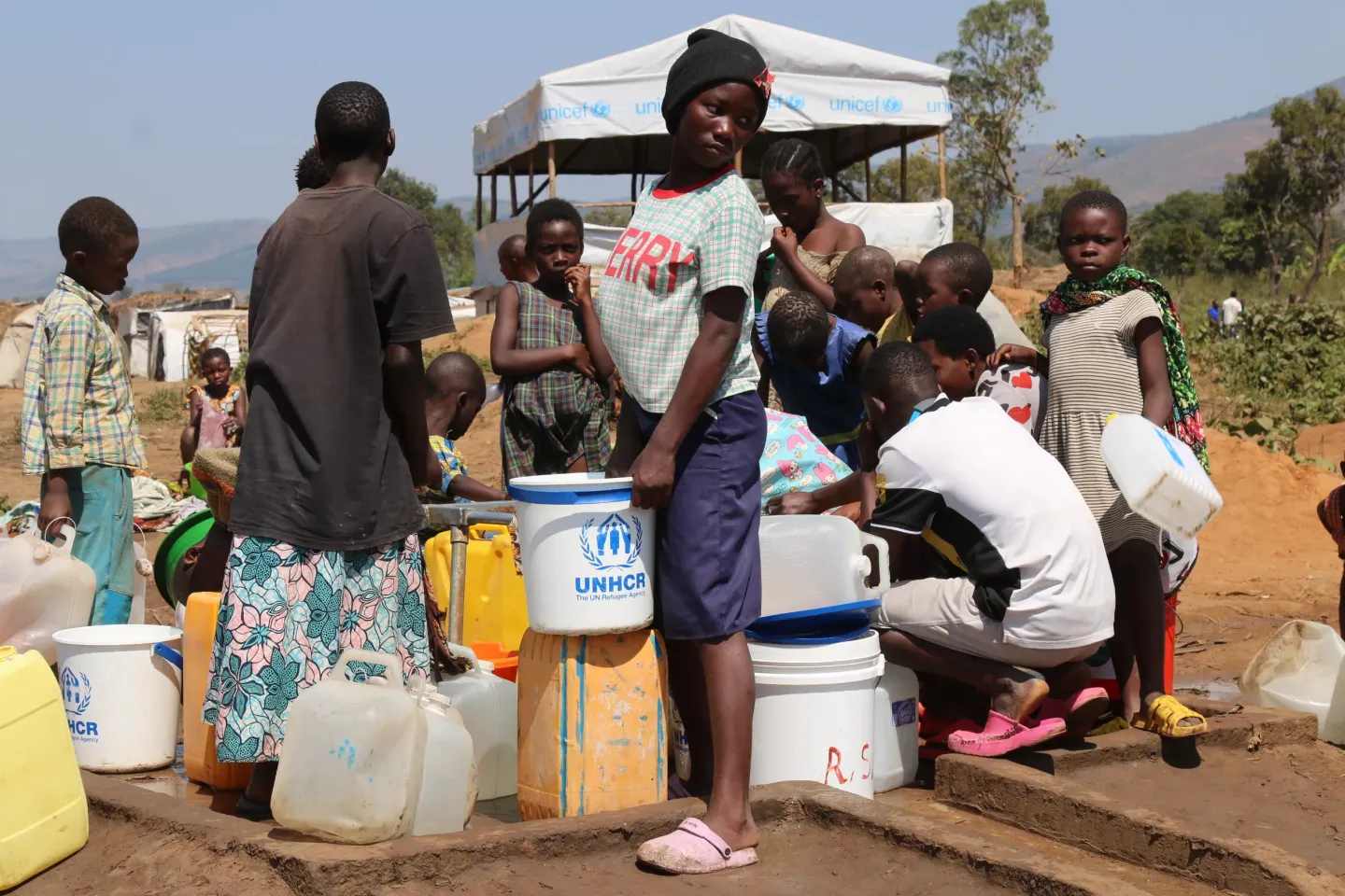 Des r&eacute;fugi&eacute;s congolais s&rsquo;approvisionnent en eau potable &agrave; l&rsquo;une des rampes reli&eacute;es &agrave; un bladder install&eacute;e par l&rsquo;UNICEF.