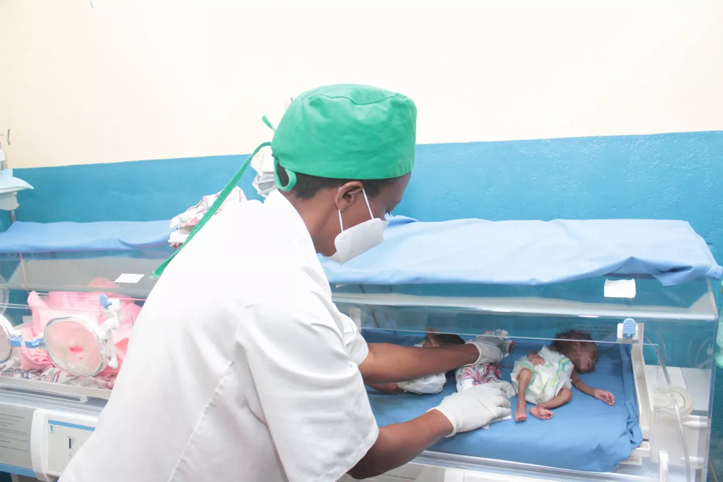 A nurse caring for an infant in an incubator at Mukenke District Hospital.
