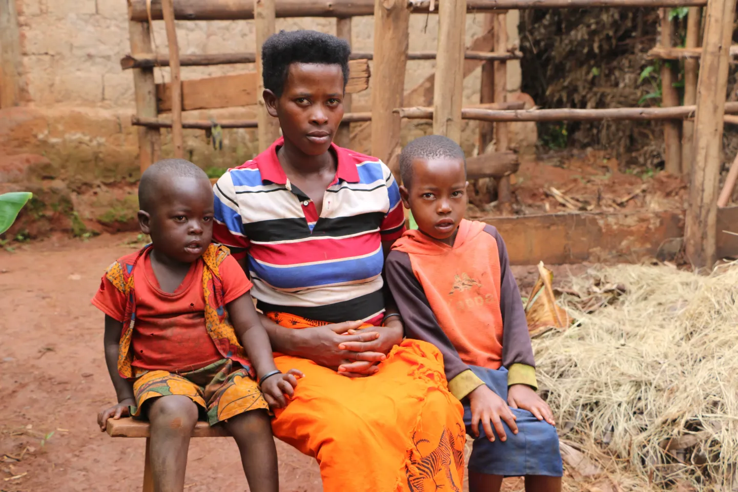  Z&eacute;phyrine Manirakiza, devant sa maison, avec ses deux enfants, Kessia et King Fiston