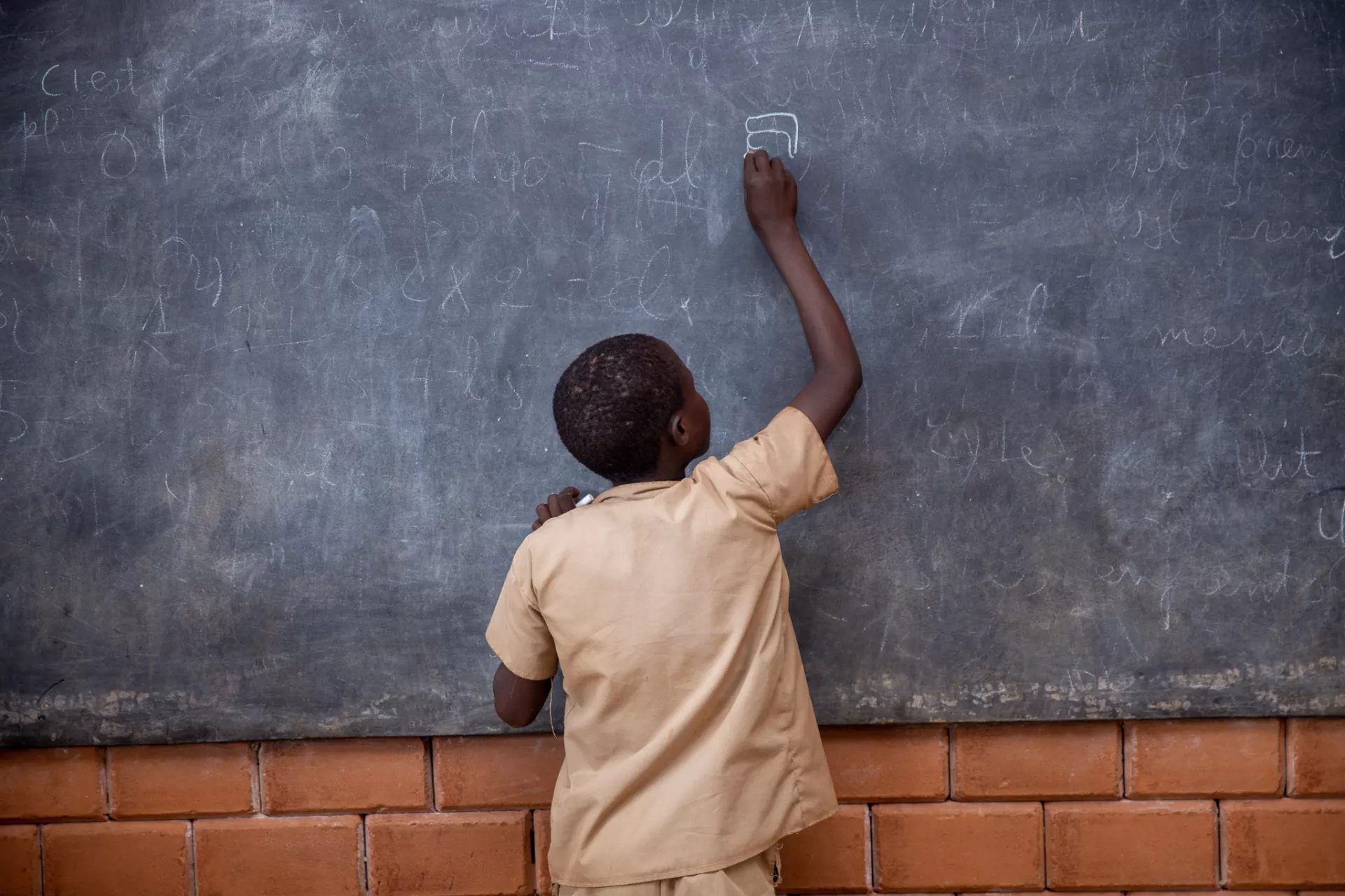 Child writing on blackboard