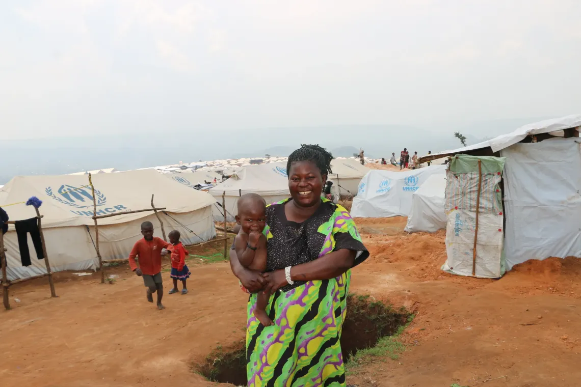 In Busuma, a refugee mother smiles with her child, grateful for the home visit from community health workers. 
