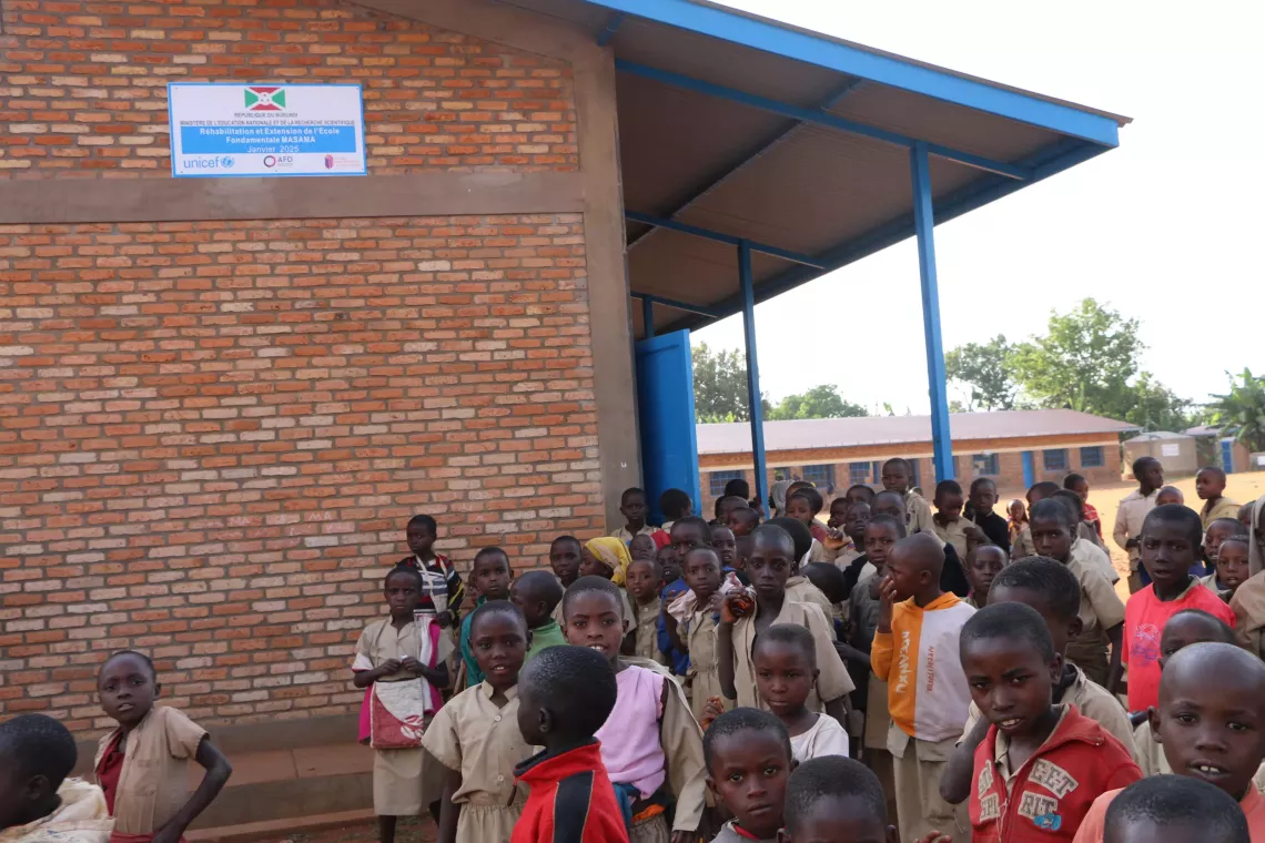ECOFO Masama: Pupils standing in front of a block of 4 classrooms newly built as part of the Twige Twese project.