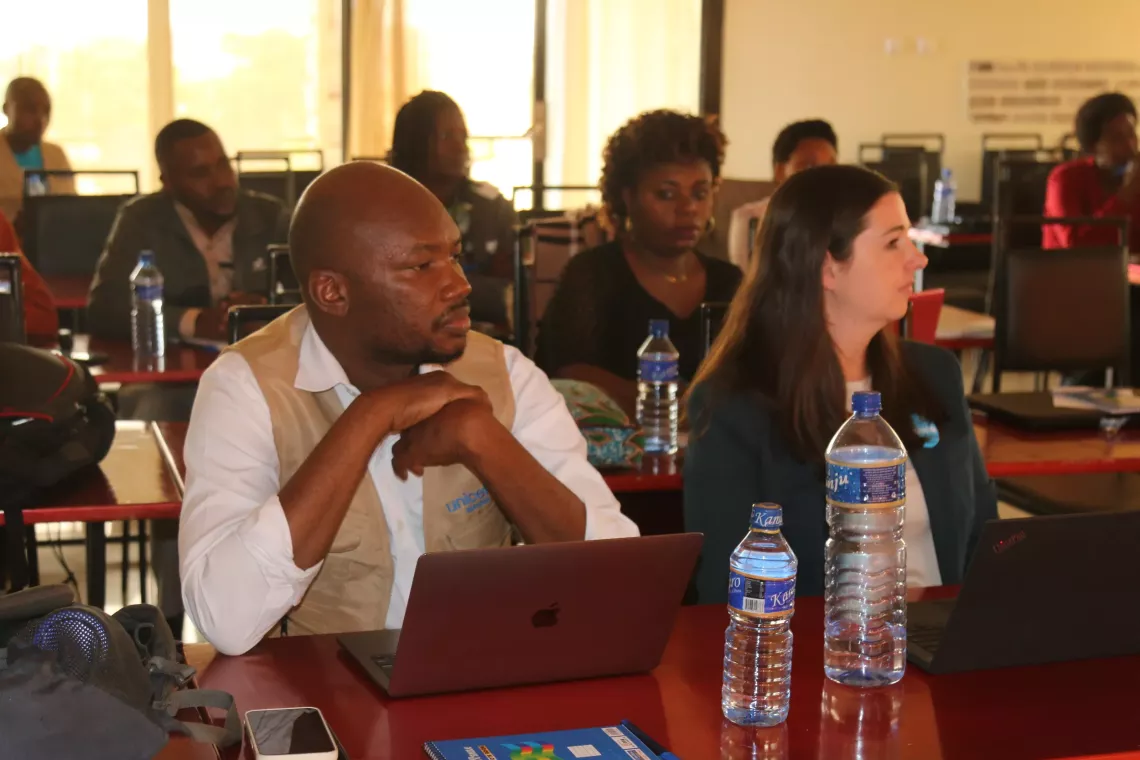 Deux agents de l&rsquo;UNICEF entrain de suivre une pr&eacute;sentation.