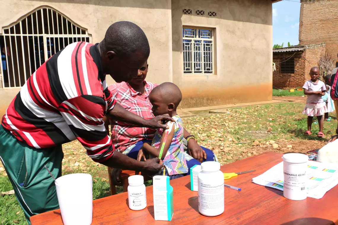 A community health worker measuring a child's branchial perimeter in Ndago hill, Muramvya province.