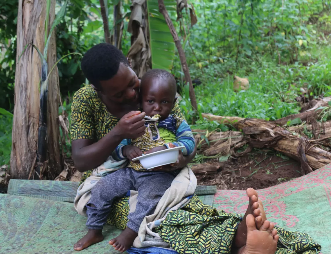 Emelyne Niyongabire 25 ans, en train de donner &agrave; son fils un repas fortifie avec la PMN.