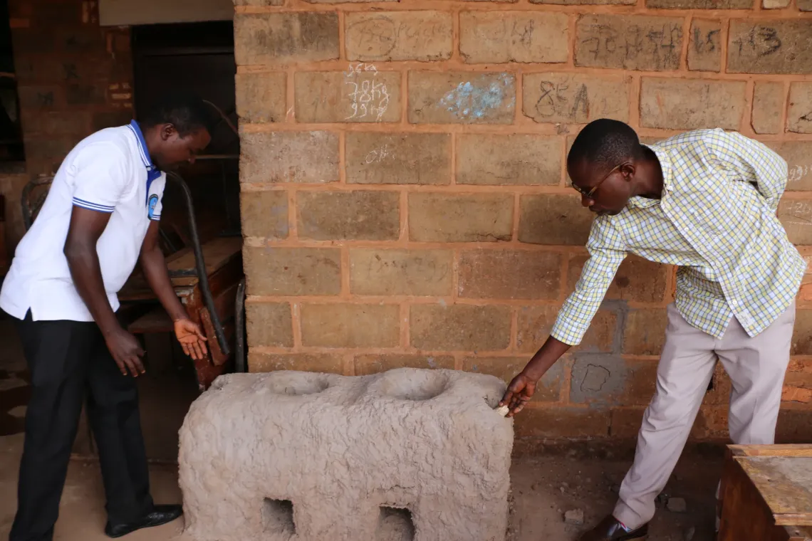Thierry and Jean Christophe, teachers at the Musenyi School of Excellence and mentors of the CREATABLE project, present an improved cookstove built with local materials.