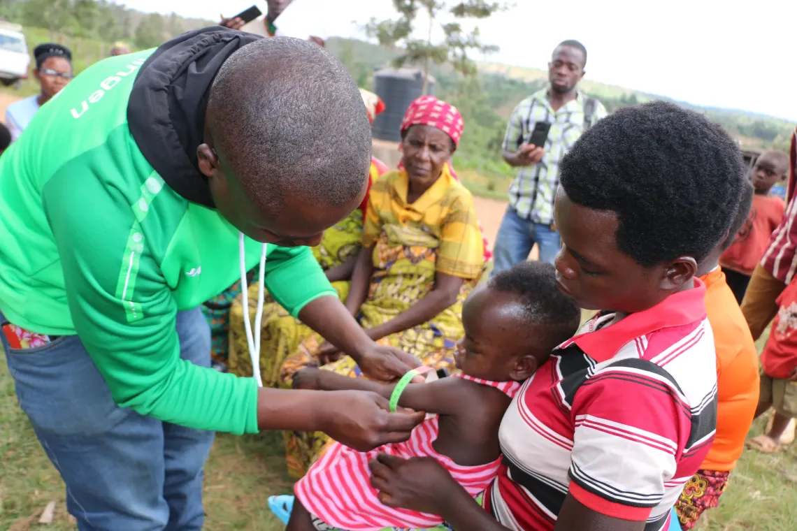 Jean de Dieu Nshimirimana, agent de sant&eacute; communautaire mesure le p&eacute;rim&egrave;tre brachial d&rsquo;un enfant &agrave; l&rsquo;aide d&rsquo;un bracelet MUAC lors d&rsquo;une visite communautaire, afin de d&eacute;tecter pr&eacute;cocement la malnutrition et orienter les enfants vers une prise en charge appropri&eacute;e  