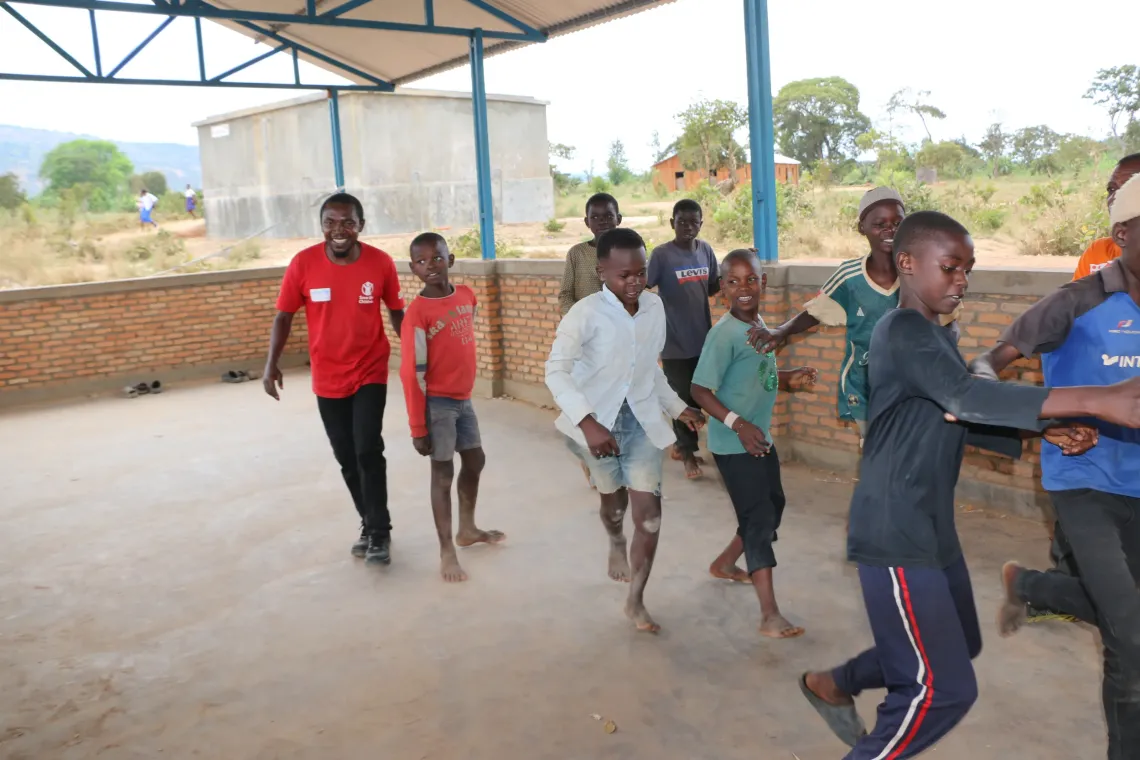 Ishara Vainqueur Munyangura, a community volunteer, plays football with children he supports as part of his child protection activities in Musenyi.