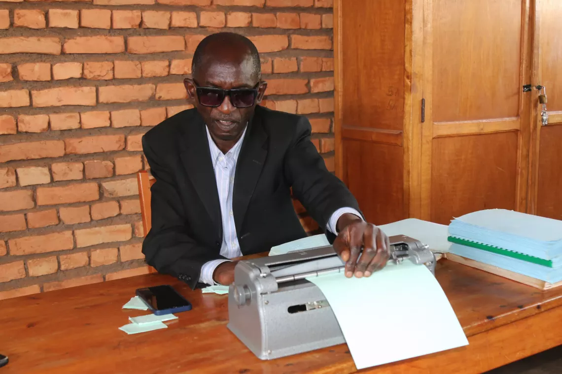 Zingiza Jean Marie Vianney, professeur malvoyant &agrave; l'ECOFO Santa Lucia, a &eacute;t&eacute; rencontr&eacute;e alors qu'il pr&eacute;parait un test pour ses &eacute;l&egrave;ves. 