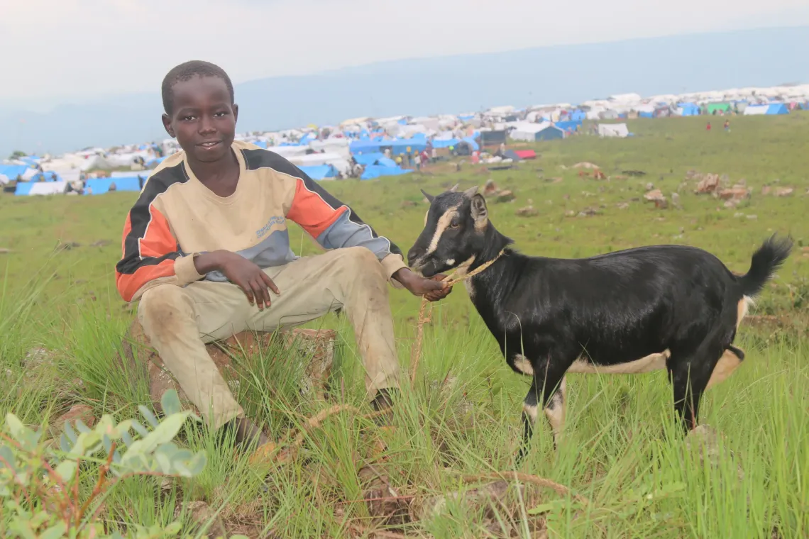 Mwangaza Amissi with the goat he is grazing.
