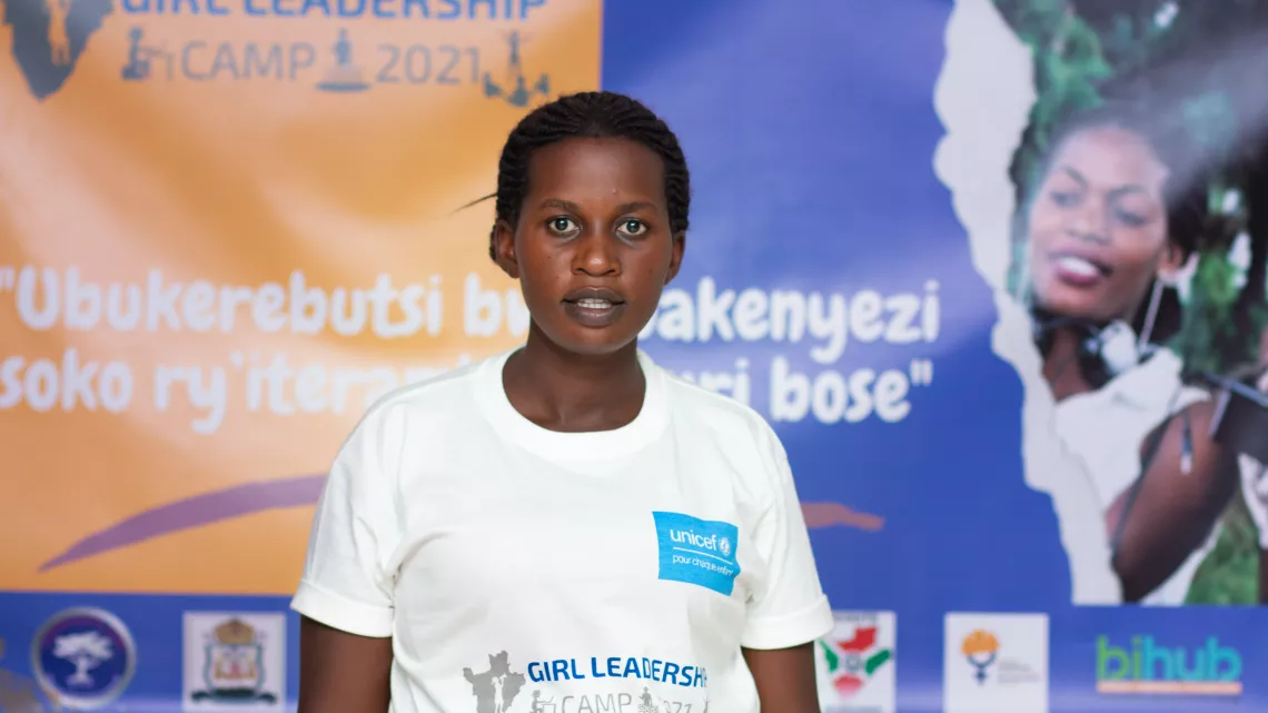 Nad&egrave;ge posing for a photograph in front of a poster.