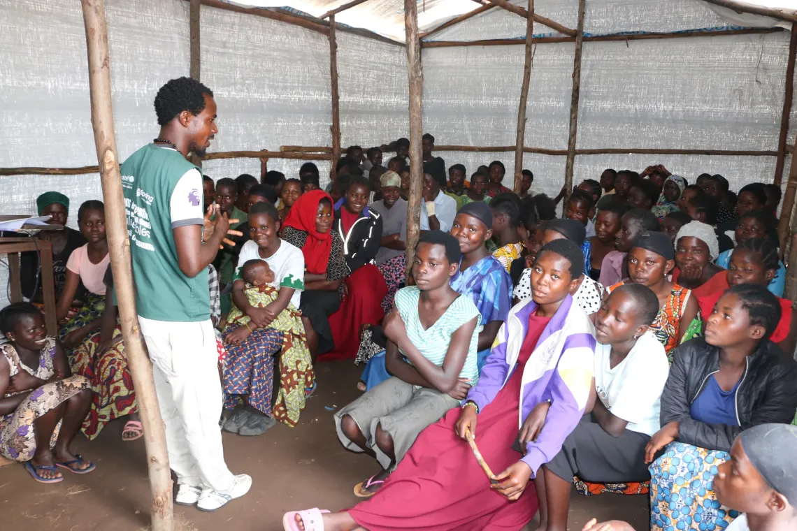A community volunteer from Spring avec un assistant Communities leading an awareness session on protection against violence for refugee girls at the Busuma camp. 