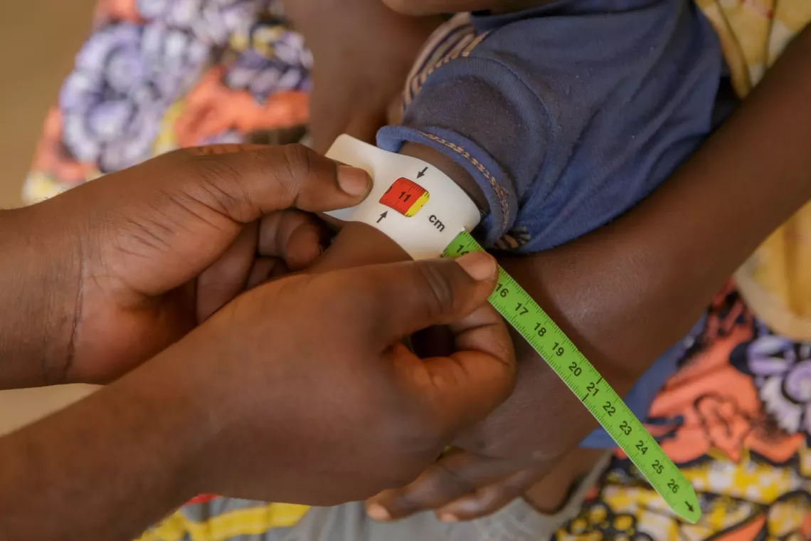 Mesure de la circonf&eacute;rence du bras d&rsquo;Abdoulkarim &agrave; l&rsquo;aide d&rsquo;un bracelet MUAC pour &eacute;valuer son &eacute;tat nutritionnel.