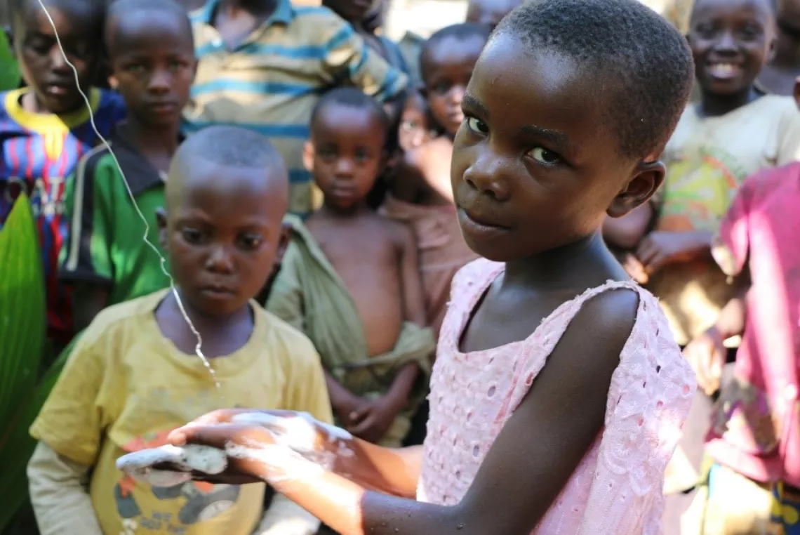 Tunza, 7, washes her hands with soap and clean water on a tippy tap, a hands-free way to wash hands after using toilet.