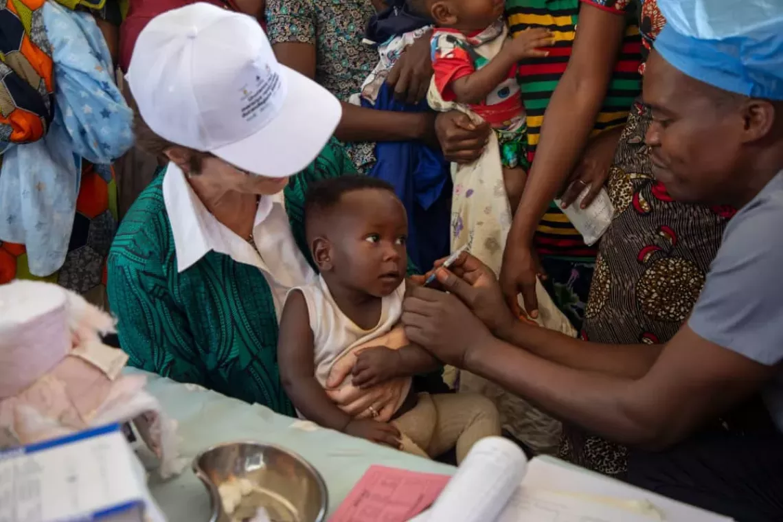La Repr&eacute;sentante de l&rsquo;UNICEF, France B&eacute;gin, tenant dans ses bras un enfant entrain de recevoir le vaccin contre le paludisme,