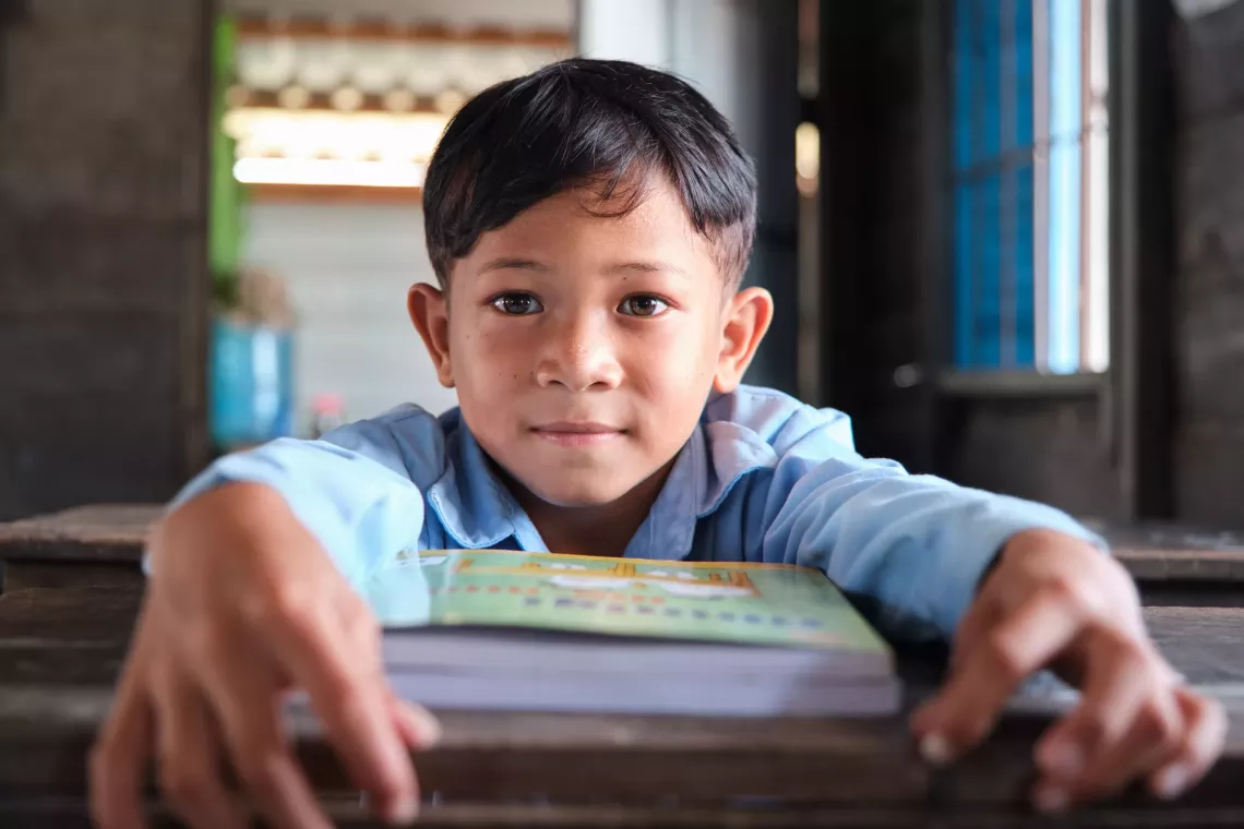 Seven-year-old Phnha, Grade 1 student, uses a new textbook provided as part of the EGR programme 