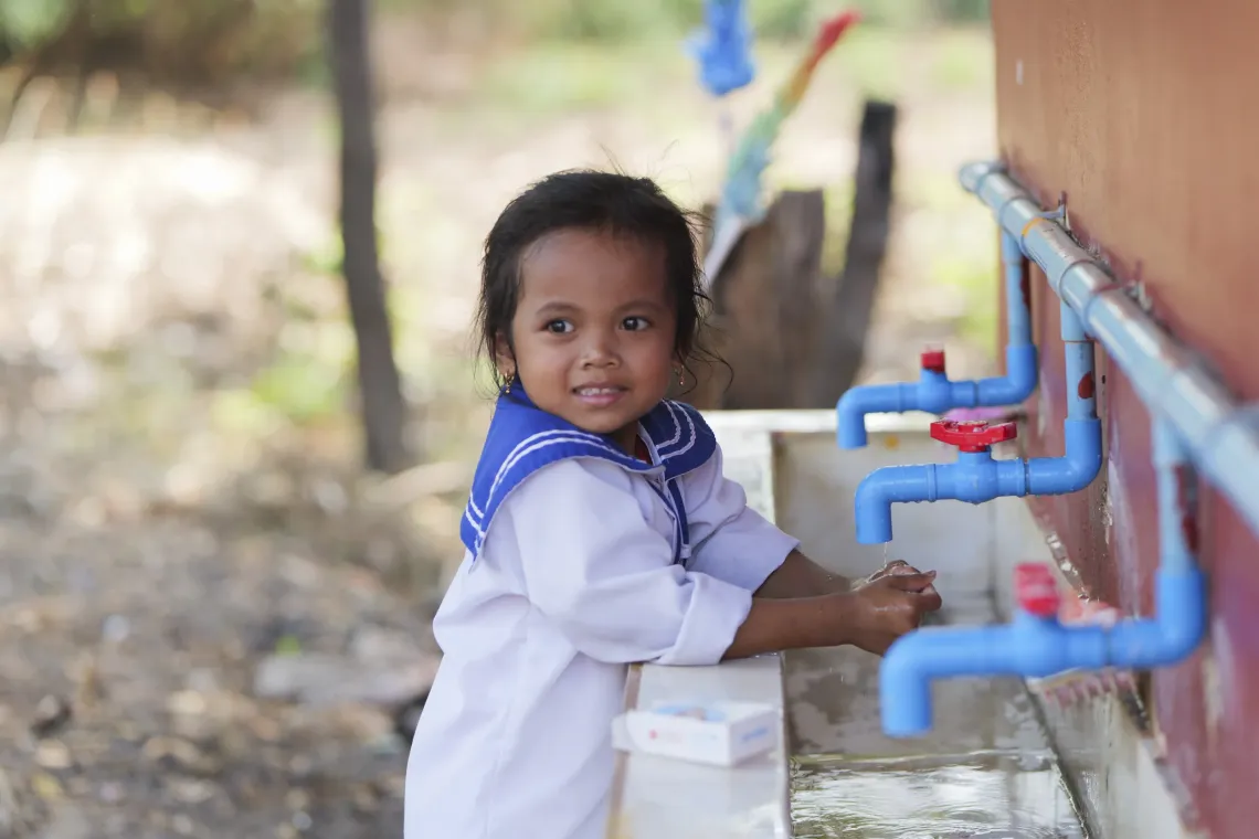 Sina washes her hands with UNICEF-provided soap before snack time