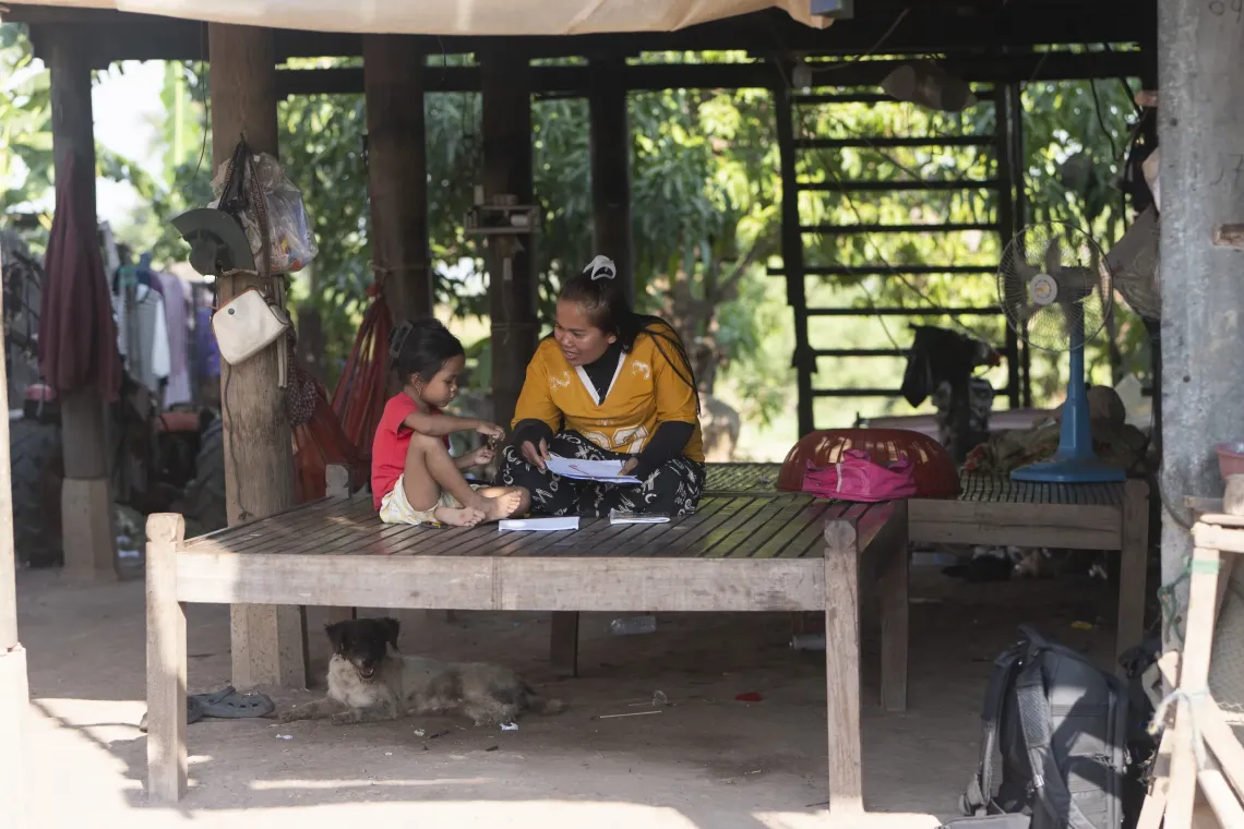 Sina shows her mother her artwork at home in Mareum village