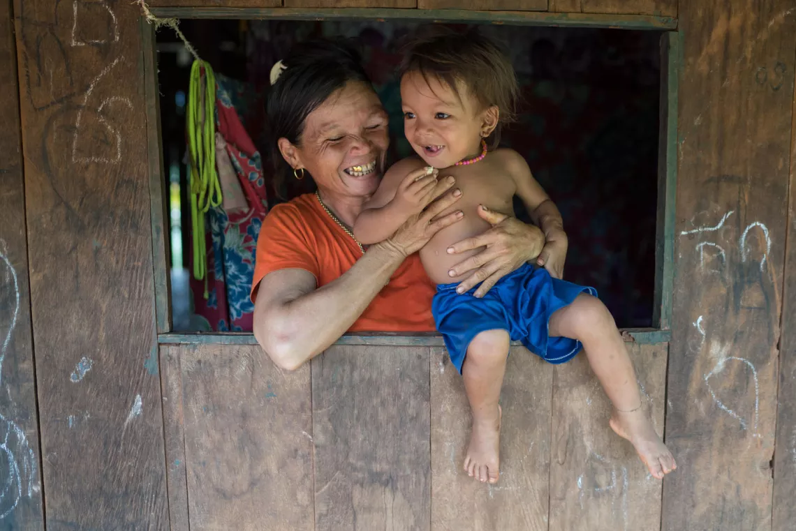 3 year old Sarika and her mother Ros Maspan play in front of their home