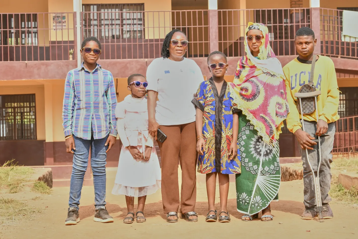 Madam Nakum Theresia Tita standing with her pupils from Temporary learning Space in Mulang 1 