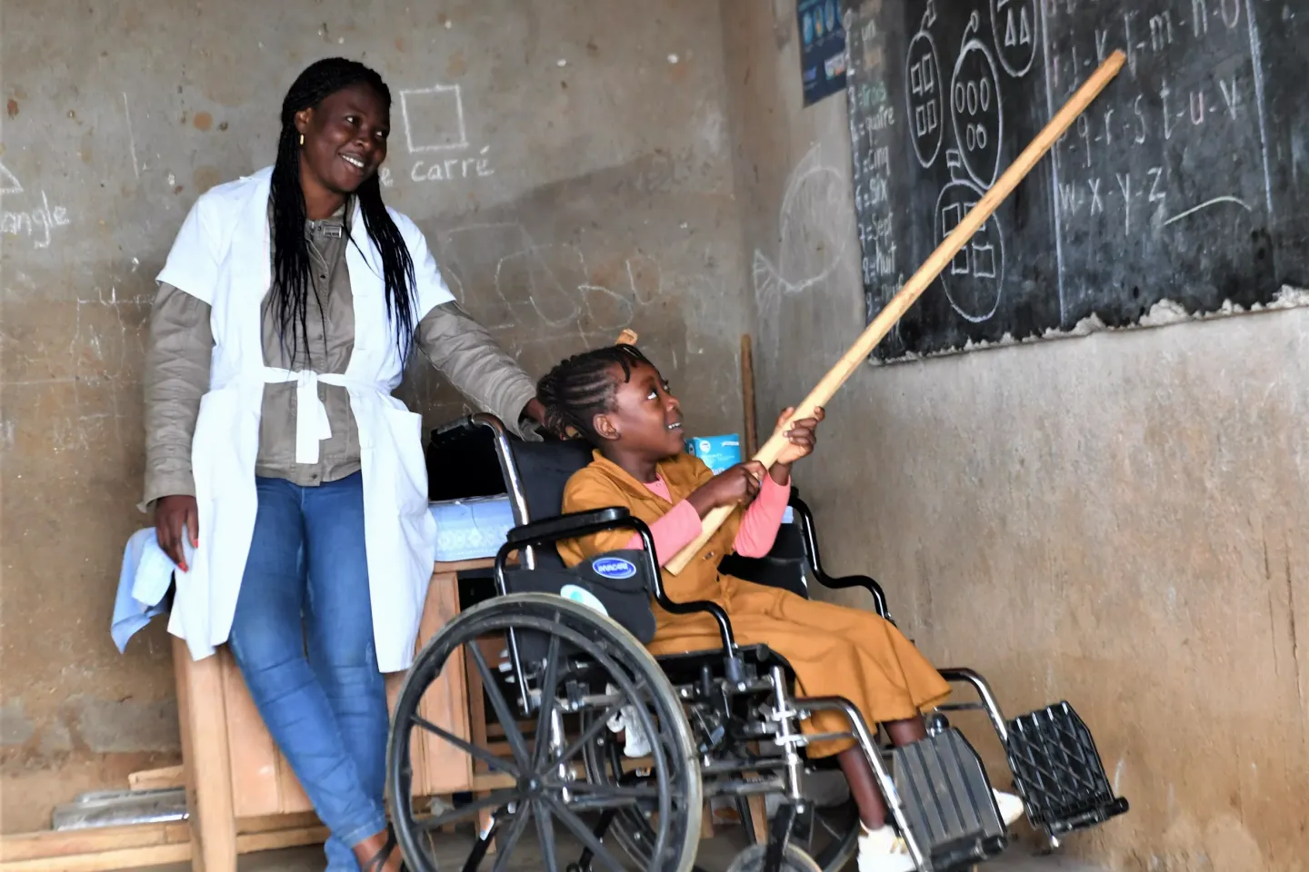A disabled pupil is reading on the board at Melong, Cameroon