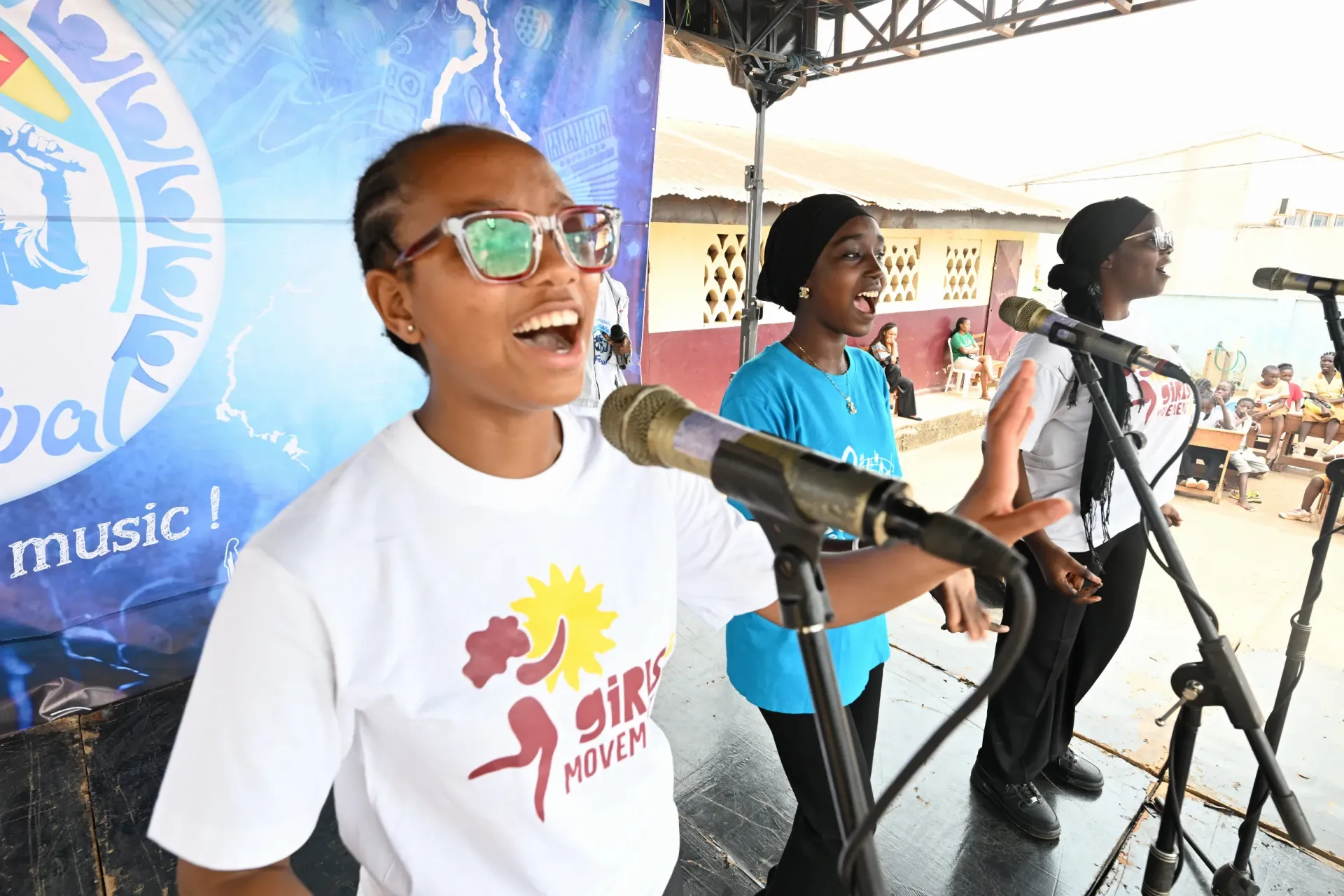 trois apprenantes de Je suis Musique chantent lors du Pr&eacute;-festival &agrave; l'&eacute;cole publique de Melen