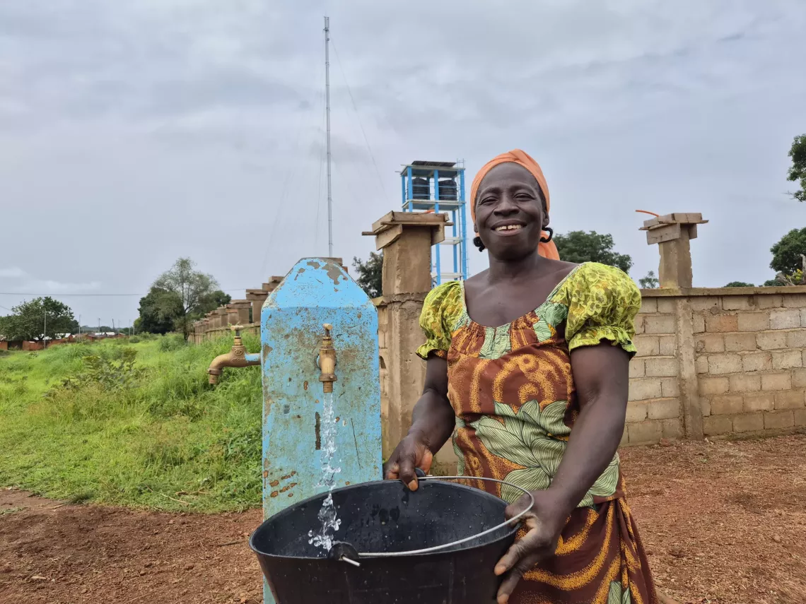 Diza Marceline, habitante de la localit&eacute; de Kalaldi heureuse de puiser de l&rsquo;eau potable pour sa famille