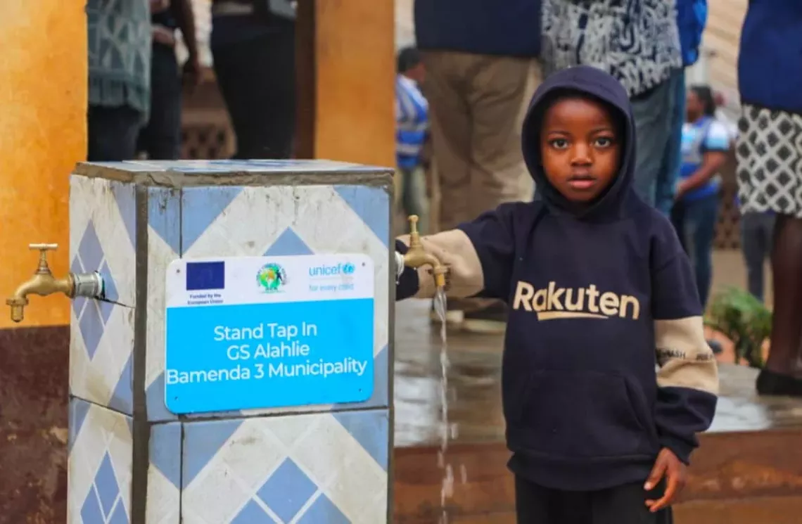 a child standing near the tap